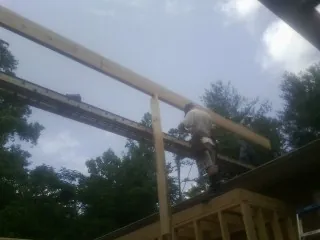 Carpenter setting a ridge beam over a new addition frame — Ice Dam Removal by Roofing Brothers in Kahoka