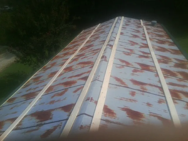 Rusted metal roof panels with new wood purlins before replacement — Storm Damage Roof Repair in Kahoka by Roofing Brothers