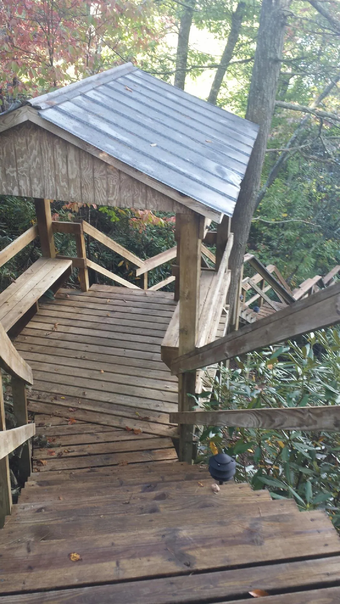 Metal roofed shelter over wooden steps on a wooded walkway — Skylight Repair & Installation work by our crew in Kahoka