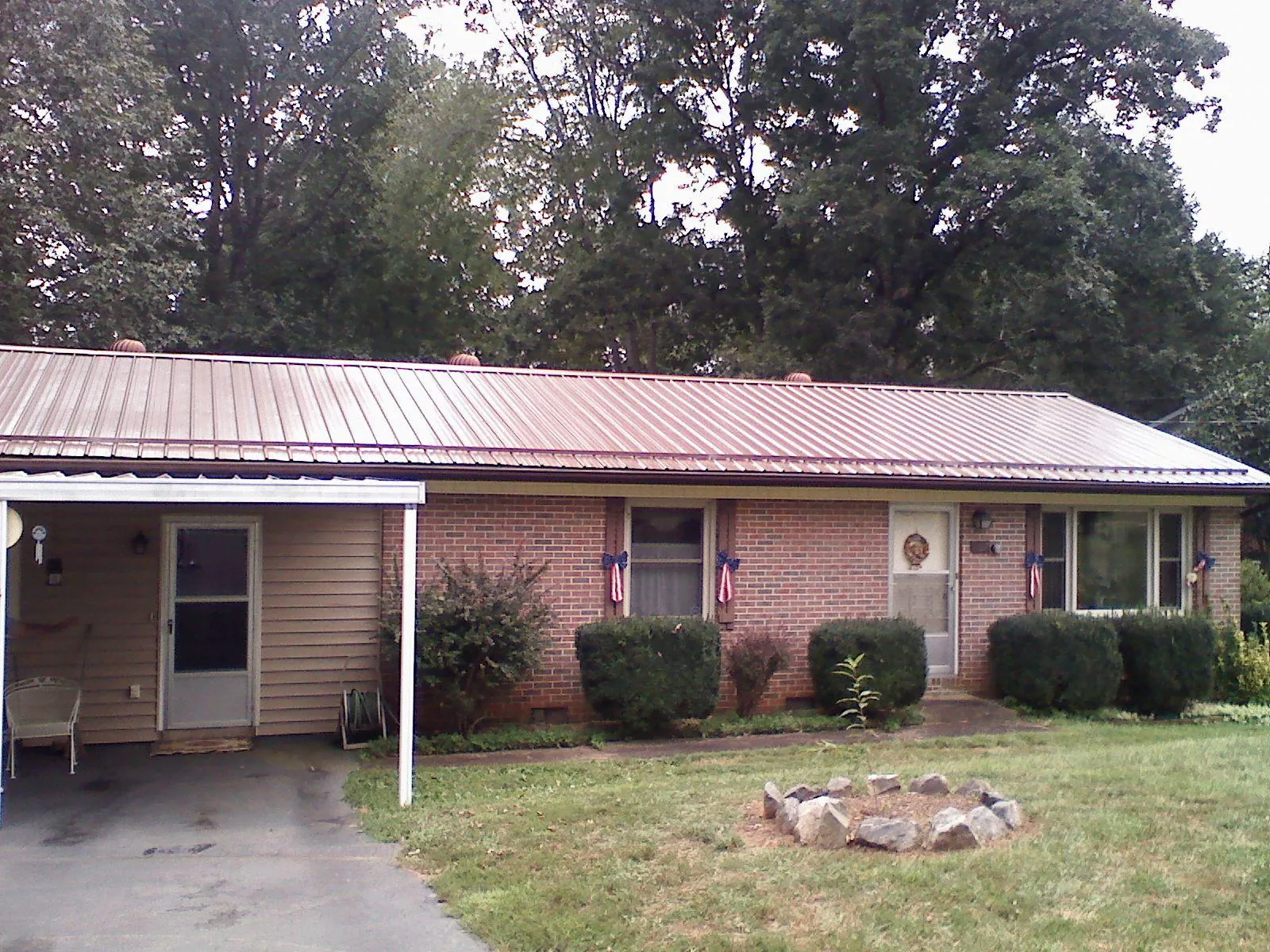 Bronze metal roof and carport on a brick ranch home — Roof Repair work by our crew in Kahoka